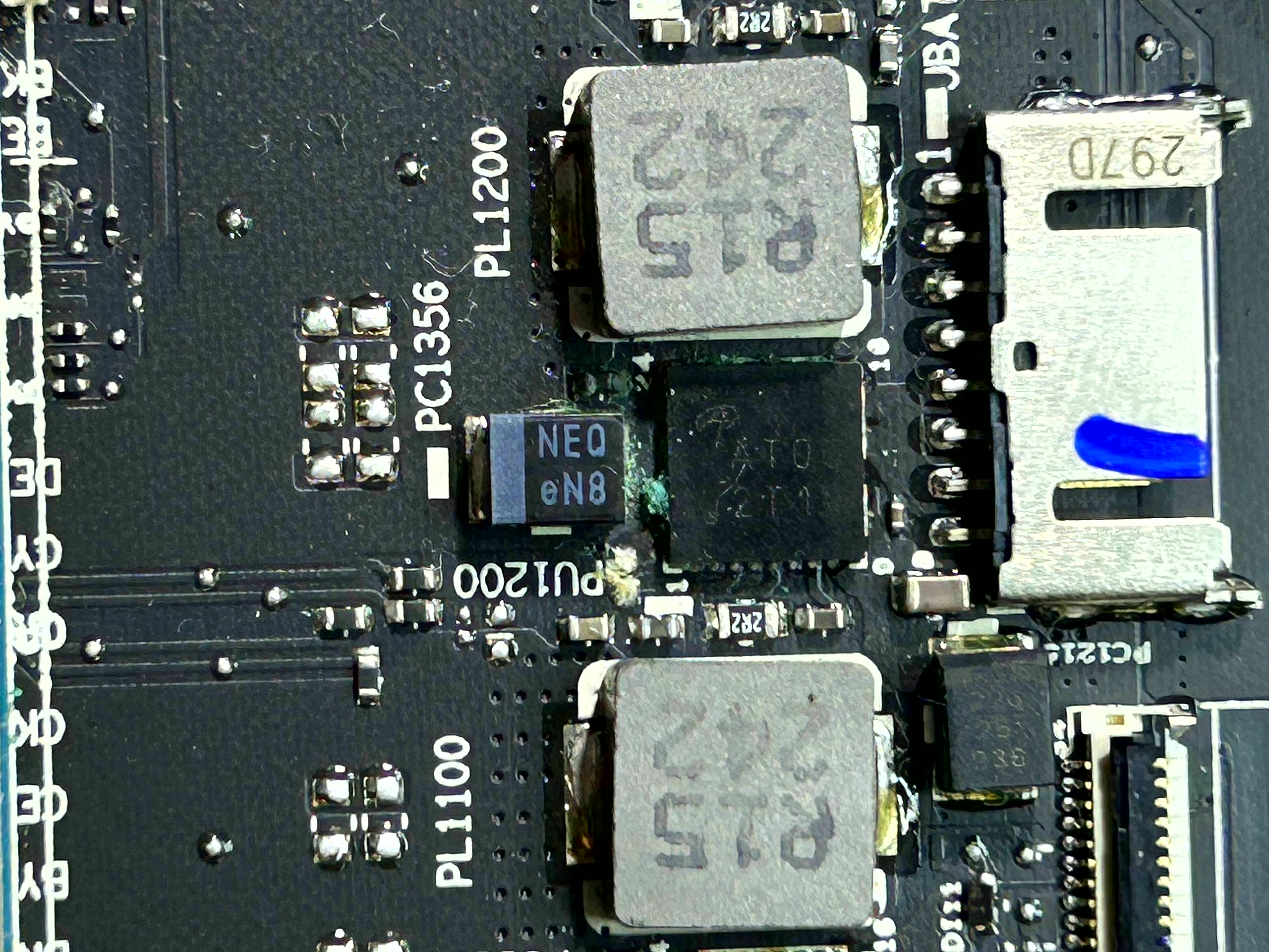 Laptop motherboard before chip-level repair · visible corrosion and damage