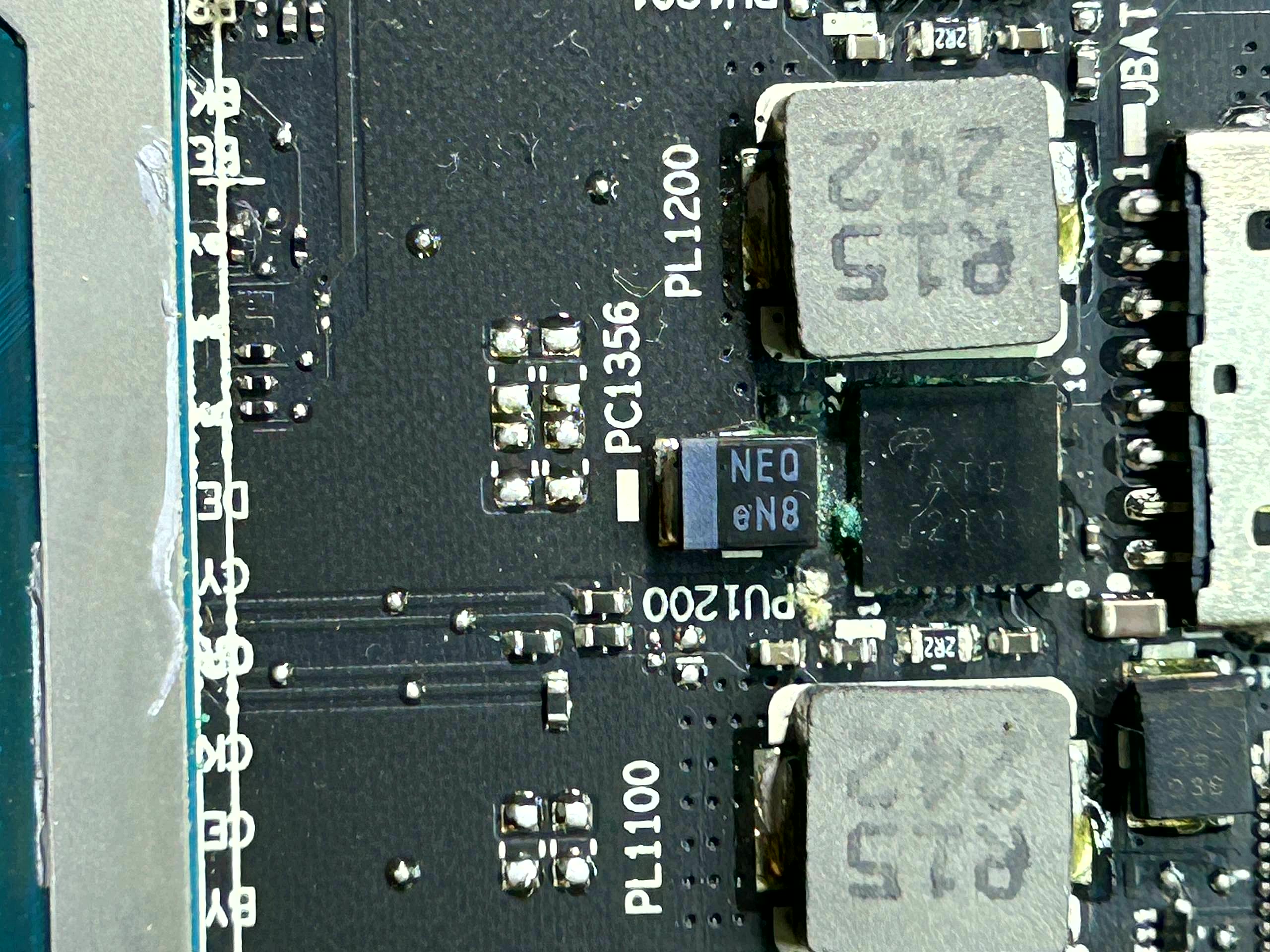 Laptop motherboard before repair · adhesive residue and contamination