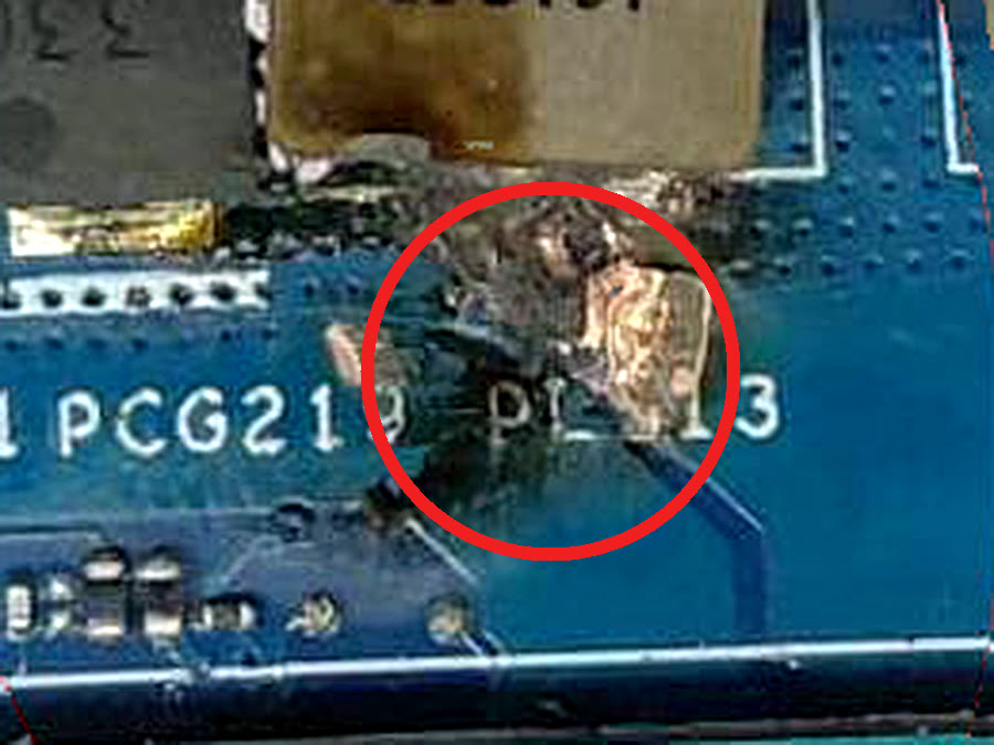 Burnt CPU power section with charred inductor on Lenovo LOQ gaming laptop motherboard before repair